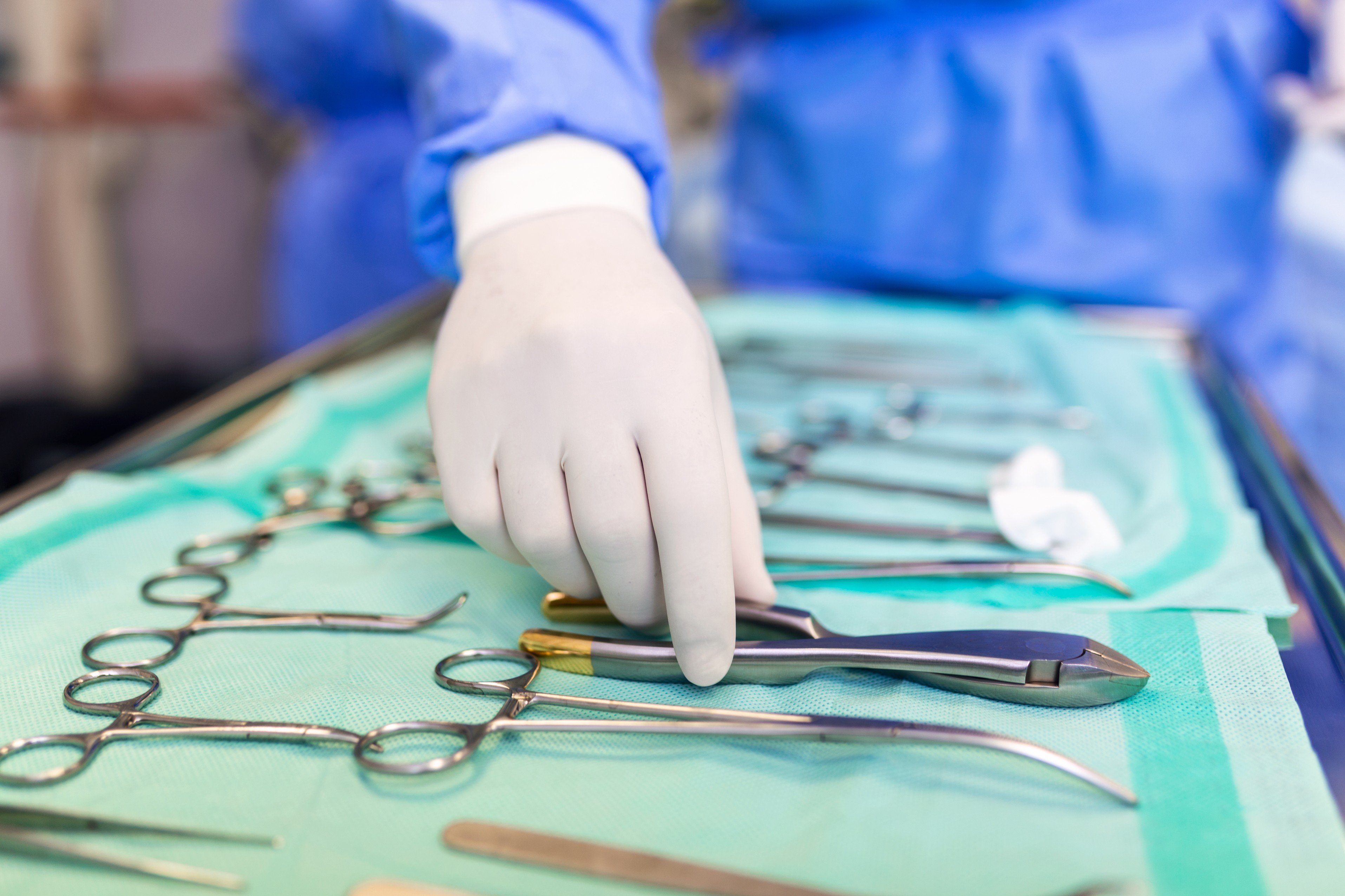 surgeon-picking-up-surgical-tool-from-tray-surgeon-is-preparing-surgery-operating-room-he-is-hospital